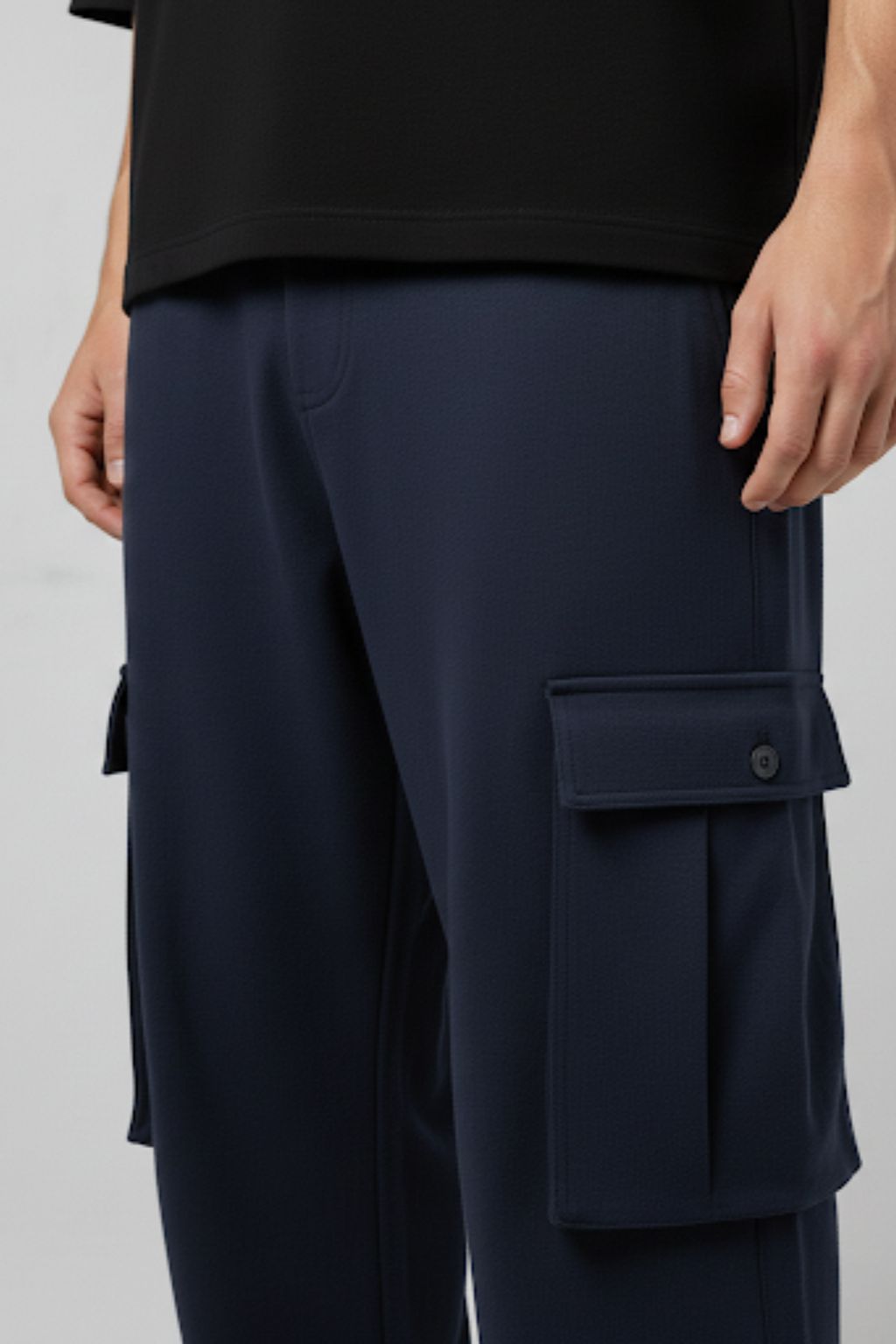 Navy cargo pants worn by a person on a light gray background
