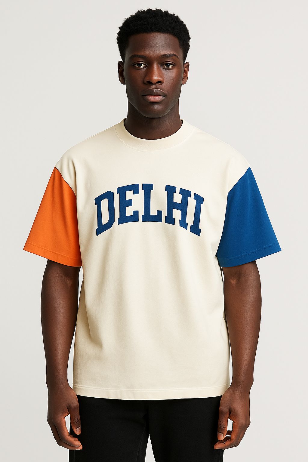 Person wearing a cream t-shirt with 'DELHI' print and orange and blue sleeves on a white background