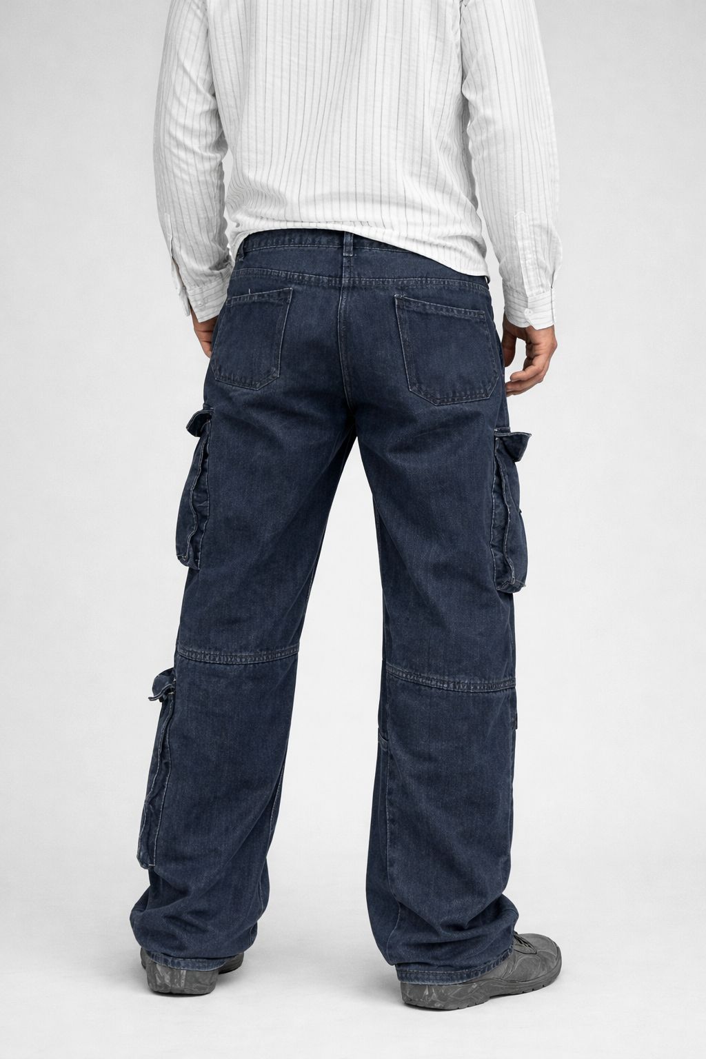 Person wearing dark blue cargo pants on a white background
