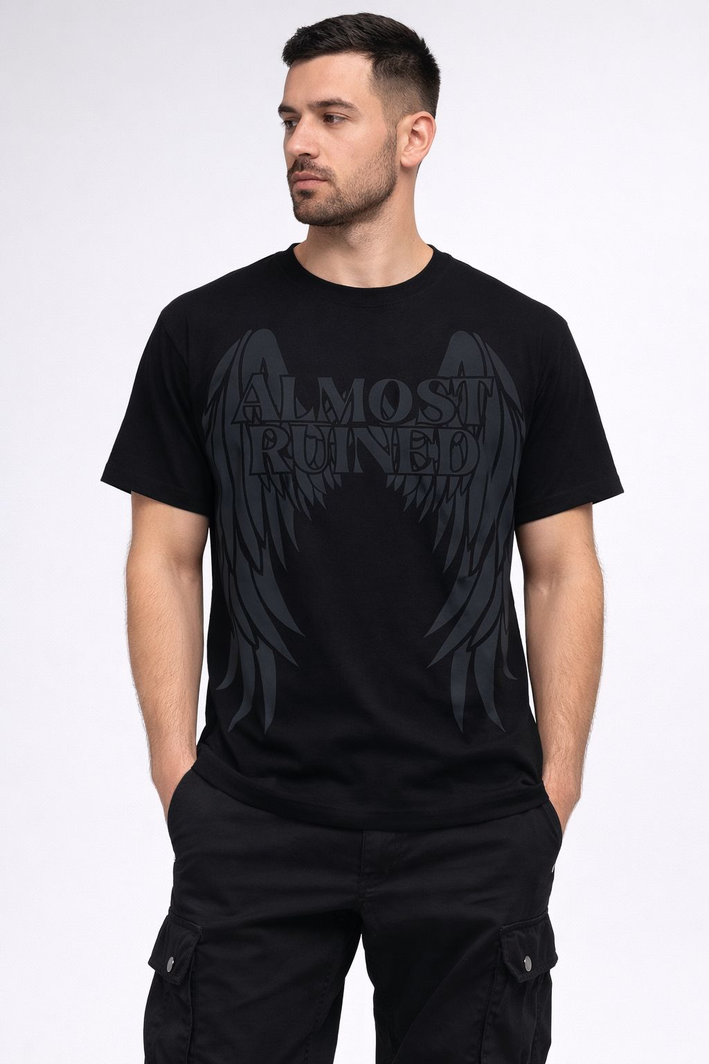 Man wearing a black t-shirt with 'Almost Ruined' graphic design on a white background