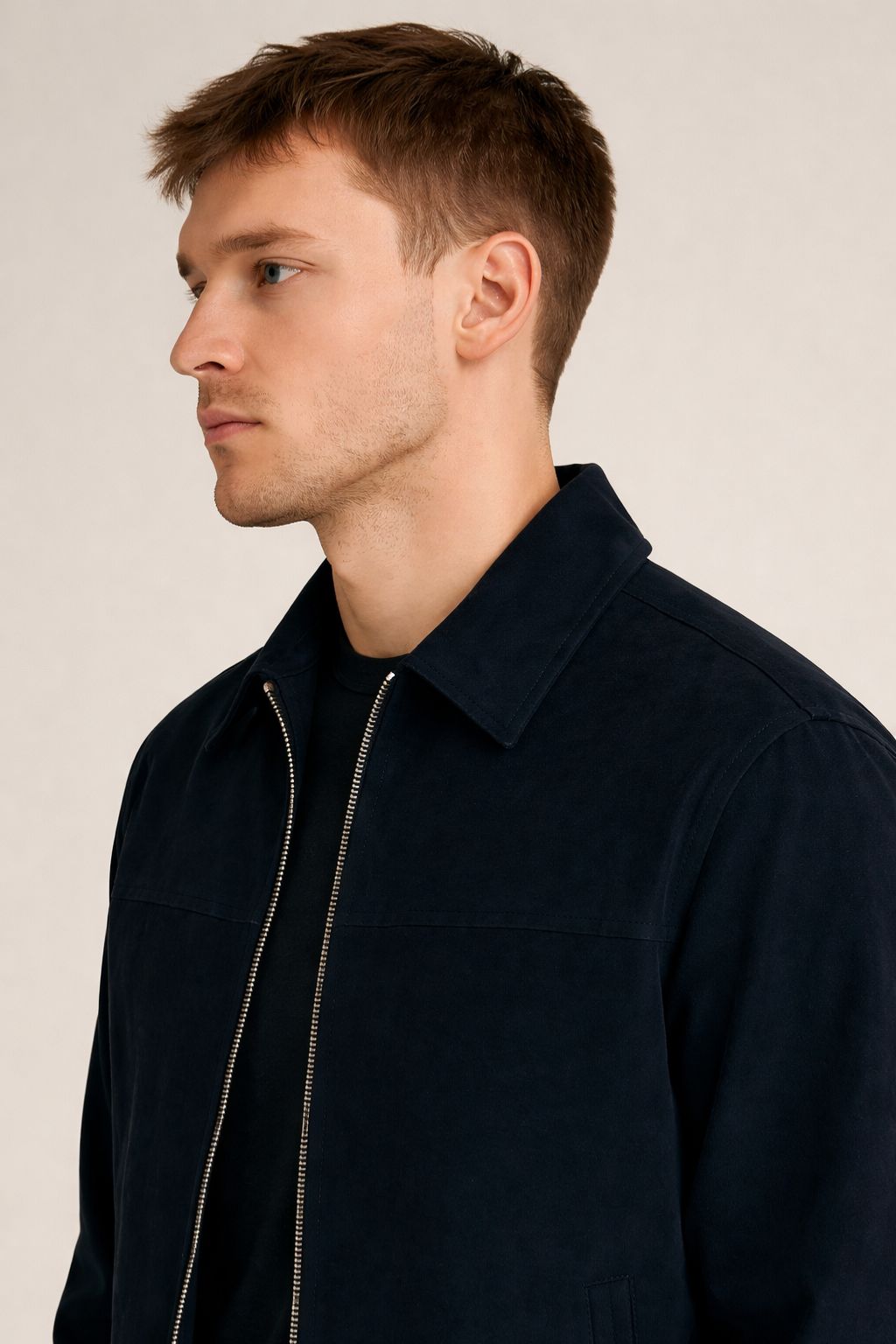 Man wearing a dark blue jacket against a plain background